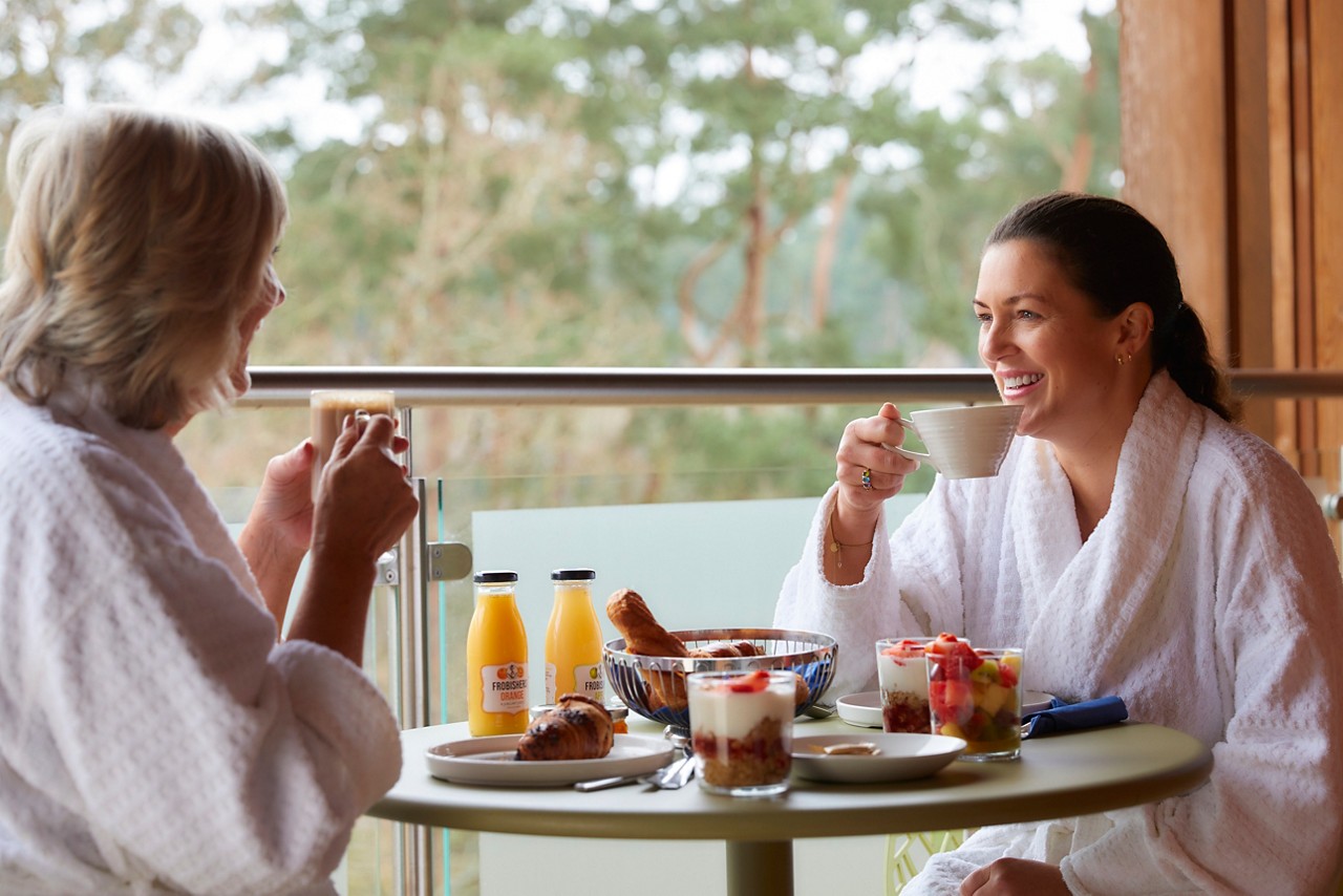 Mother and daughter enjoying breakfast on their Spa Suite balcony.